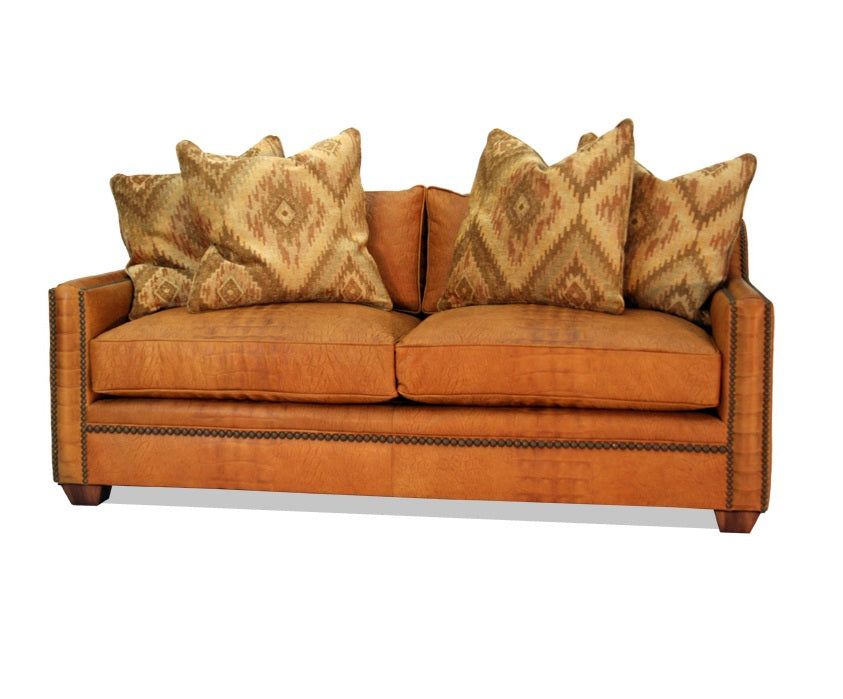The Modern Nailhead Loveseat is the perfect blend of comfort and modern style. This sofa has a luxurious feel with its detailed nailhead trim, making it the ideal piece for any modern or western space.