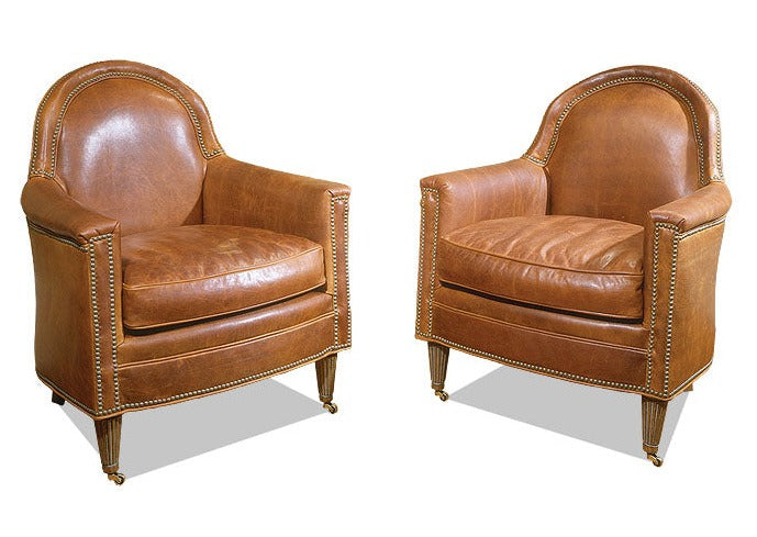 Cognac Leather Bourbon Chairs feature high-quality cognac leather upholstery with studded detail, giving them a luxurious and western appearance. The distressed look makes them both stylish and comfortable, and the movable base allows for easy rearrangement.
